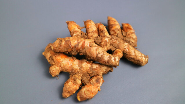Fresh turmeric roots on gray background
