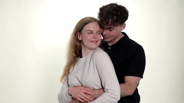 A young couple is captured in a tender embrace, showcasing affection and intimacy. The man gently kisses the woman s neck while she leans into his touch, conveying a sense of romantic connection and h