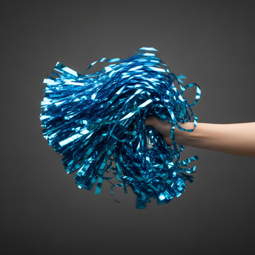 A hand holding a blue pom-pom against a dark background