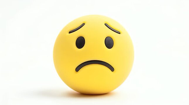Close-up of a human hand slowly pressing or squeezing a sad yellow emoji stress ball on a seamless white background.