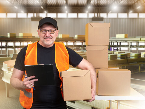 Warehouse logistics, Parcel sorting. Delivery worker checks packages with clipboard at distribution center near conveyor equipment.