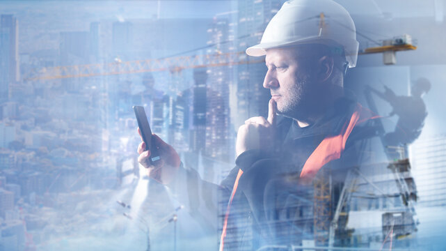 Construction management, Mobile coordination. Site engineer checks smartphone during urban building project planning and contractor communication.