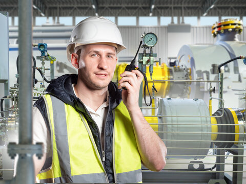 Industrial inspection, Equipment monitoring. Engineer performs visual check of operating industrial machinery and production systems at factory.