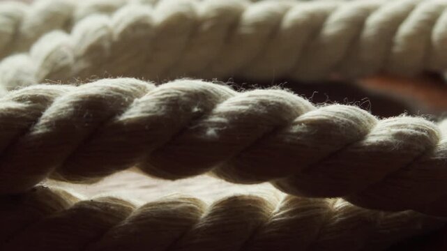 Slow macro side slide over a strong rope, emphasizing texture, tension, and its role as a potential investigative object.