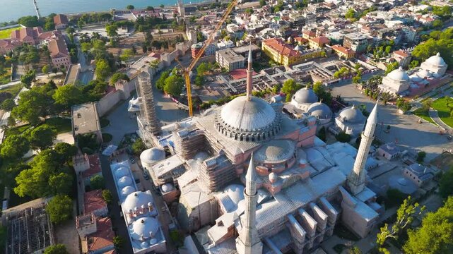 Istanbul, Turkey. Hagia Sophia Grand Mosque, massive central dome and minarets surrounded by extensive scaffolding and a tower crane, aerial view during daylight restoration work. Aerial View