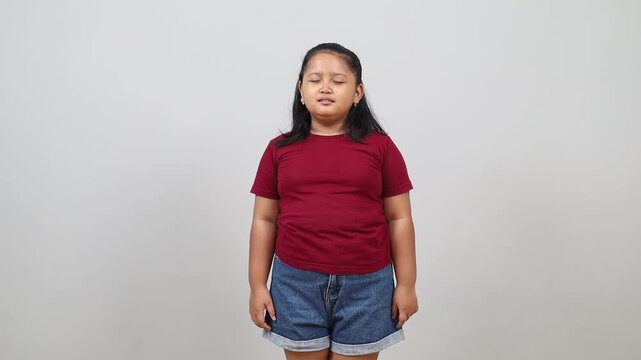 Frustrated Asian little girl crying and panicking in despair, having problems, standing upset on a white background.