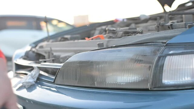The process of polishing car headlights outdoors. 