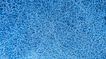 A detailed macro shot showcases the soft, curly looped texture of a bright cyan blue fabric, perfect for cozy winter clothing designs, furniture upholstery texturing, and web backdrops. © Александр Серебрянни
