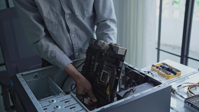Asian IT engineer man fixing mainboard in pc case
