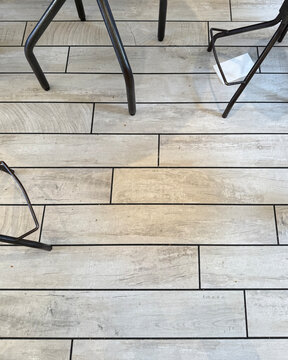 Coffeehouse floor with black chair legs and a white napkin