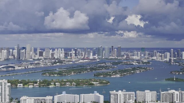Aerial skyline of Miami Beach, Florida at sunset with bay, highrise buildings and dramatic clouds. g.
