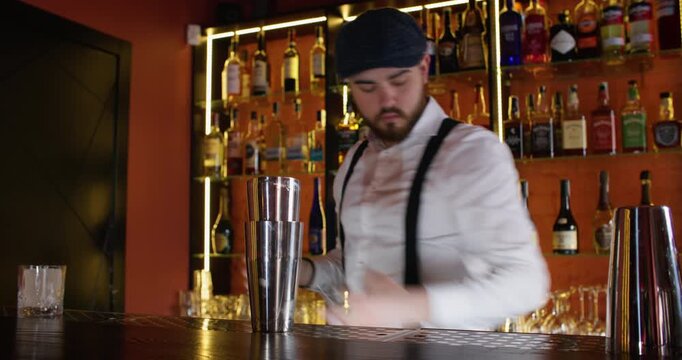 Bartender working. Summer bar. Male barman making cool cocktail for serving pouring alcohol using professional shaker at pub counter.
