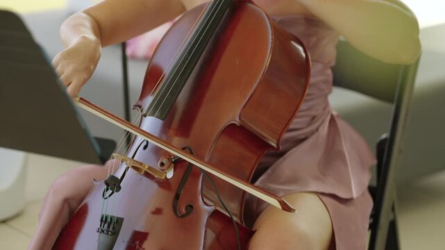Female Cellist Playing Classical Cello Bow During Elegant Live Wedding Ceremony Performance In Soft Light