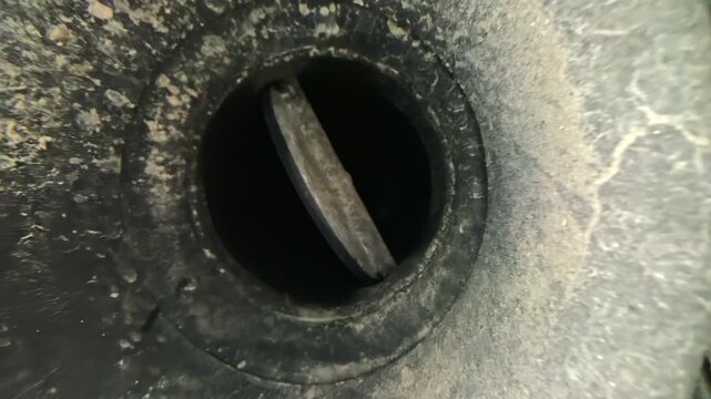 Closeup of dual car exhaust pipes with visible internal valve mechanism details