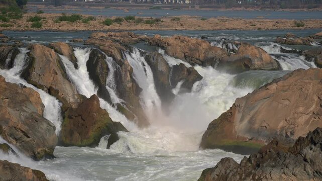 Long focal length slow motion shot of Khone Phapheng falls, mostly static shot with slight camera movements across the falls.
