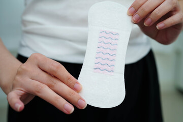 Asian woman holding sanitary napkin pad for hygiene menstrual period cycle protection. © Pakawadee