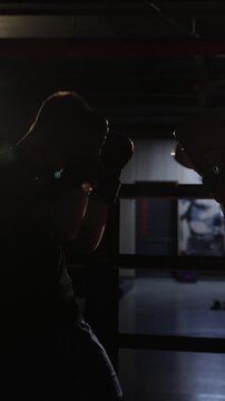 Silhouette of two fighters sparring in a boxing ring