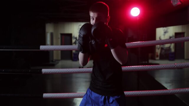 Young male boxer training in the ring