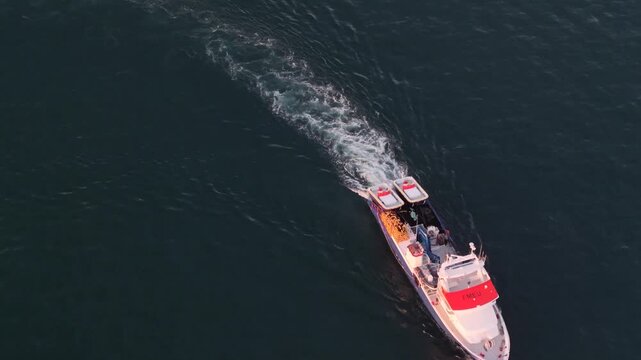 Pesquero o barco de pesca profesional saliendo a faenar , cenital a&eacute;rea al atardecer