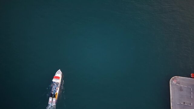 Pesquero o barco de pesca profesional saliendo a faenar , cenital a&eacute;rea al atardecer