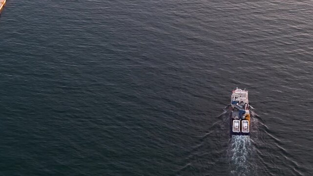 Pesquero o barco de pesca profesional saliendo a faenar , cenital a&eacute;rea al atardecer