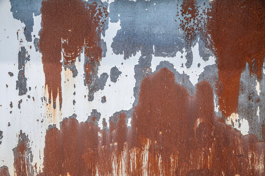 Rustic Rusted Metal Sheet Background, Distressed Metallic Surface with Flaking White Paint and Heavy Corrosion Texture.