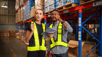 Obraz premium Warehouse manager talking and checking product in warehouse.