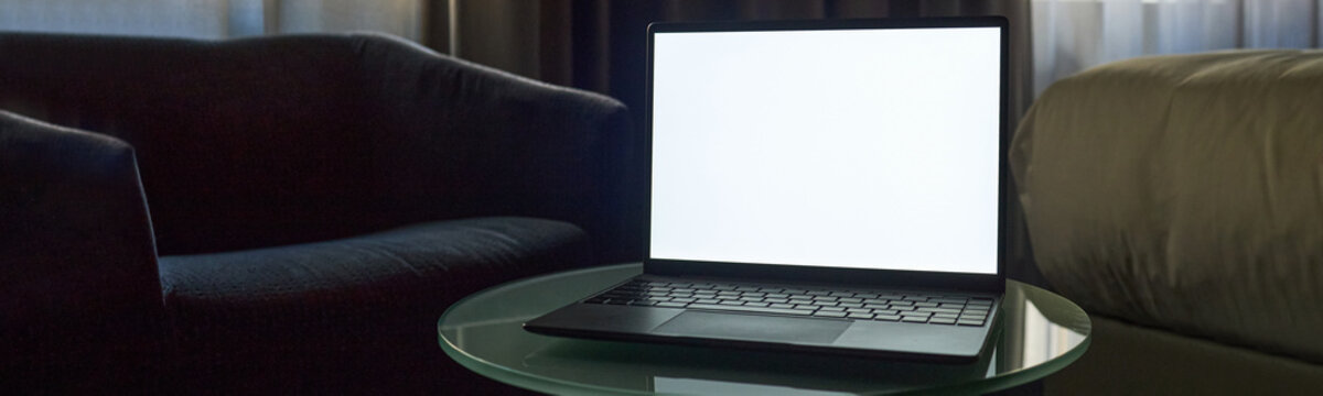 Wide shot of laptop displaying blank screen on table, presenting mockup workspace for online business, remote work, or digital marketing. Ideal for website banner, app promo, or ad design, header