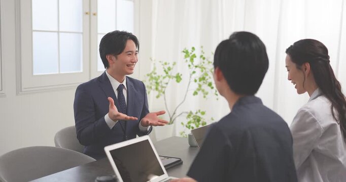 クリニックの会議室で打ち合わせをする若い医師とビジネスマン