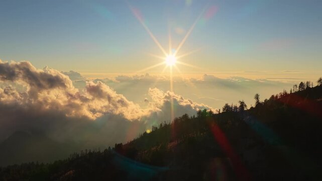 Golden sun shining above clouds over Nevado de Colima mountain at sunrise, Mexico