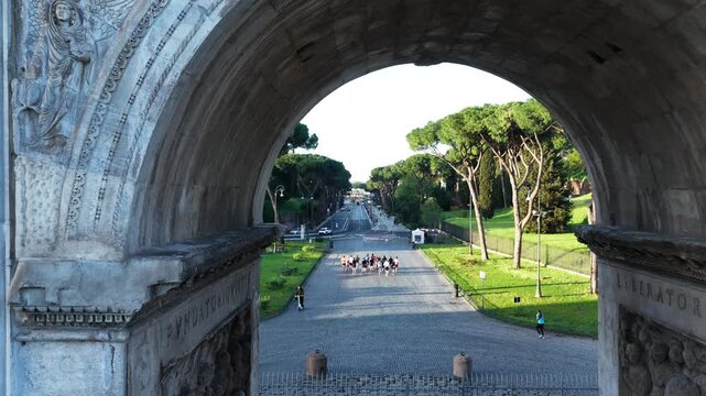 I runner corrono nella citt&agrave; eterna davanti al Colosseo e l'arco di Costantino a Roma.
Ripresa aerea col drone in una mattina soleggiata..