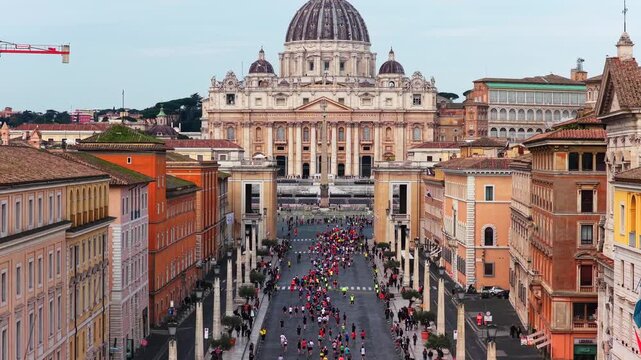 I runner corrono nella citt&agrave; eterna davanti a San Pietro a Roma.
Vista dall'alto dei corridori durante la maratona di Roma, Italia.
