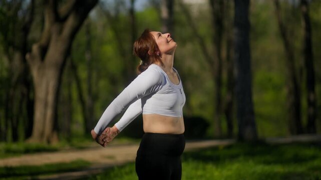 45 year old female doing chest opener stretch in outdoor fitness session