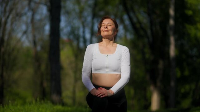 45 year old woman doing kneeling lunge stretch in outdoor fitness session