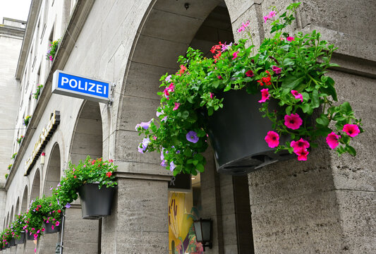 Schild Polizei und Blumenampel am Rathaus in Neuss, Deutschland