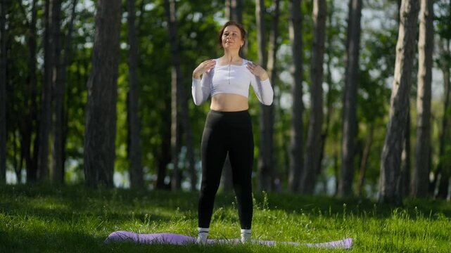 45 year old woman doing seated forward fold stretch in outdoor park