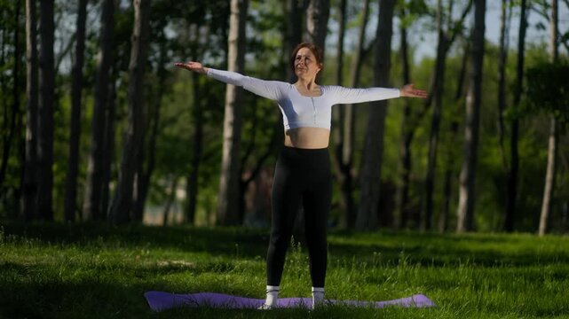 Seated forward bend stretch by 45 year old woman on purple yoga mat