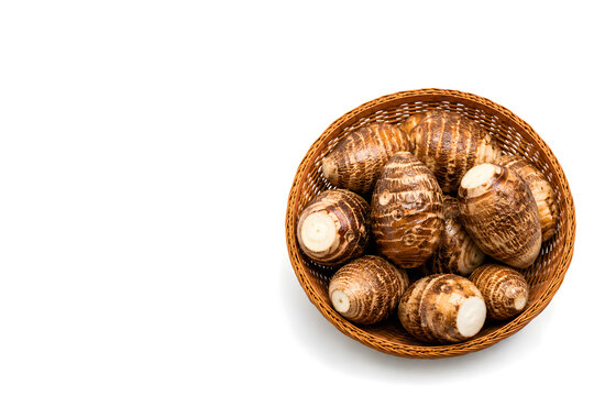 Raw Taro Roots in a Woven Basket Isolated on White Background with Ample Copy Space
