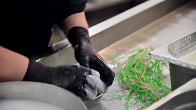 Hands forming burrata cheese in kitchen, bowls and ingredients visible in background