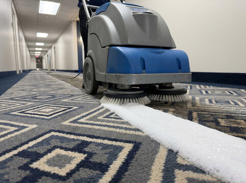 Commercial polypropylene hotel rug cleaned with walk-behind encapsulation machine laying down crystalline foam stripe