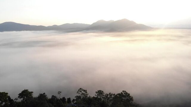 Beautiful scene view of misty in the morning with the mountain, farm, small village and forest at sunrise time in Loei province, Thailand.