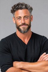 Obraz premium Confident mature man portrait with beard and gray hair smiling in casual black sweater, studio close-up