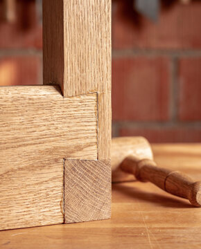 Razor-sharp macro view of an intricate white oak mortise and tenon joint. Raking light accentuates the micro-pores, defining structural perfection and the physical truth of quiet luxury.
