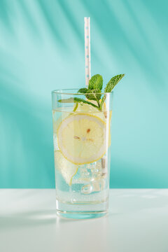 Fresh lemon and mint non alcoholic drink with ice on blue background