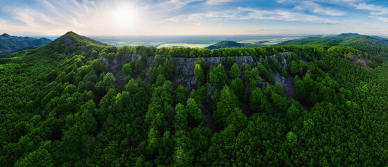 Fototapeta premium Colorful sunset in the mountains of the Little Carpathians in Slovakia with fresh green grass and leaves on the trees in the valley, spring evening