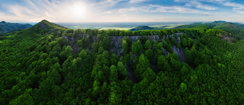 Colorful sunset in the mountains of the Little Carpathians in Slovakia with fresh green grass and leaves on the trees in the valley, spring evening