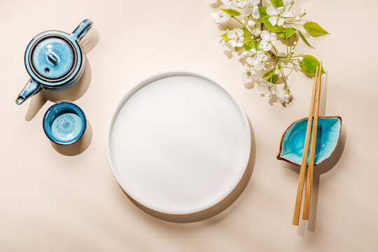 Empty white plate with chopsticks and blue bowl