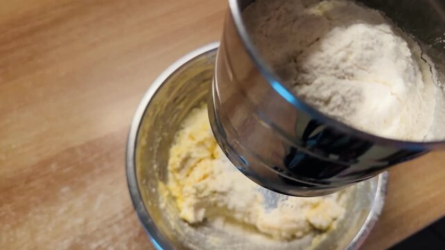  a mechanical flour sifter and sifts flour into dough during the baking process