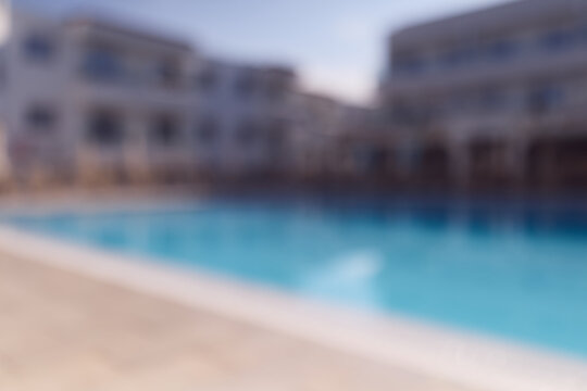 Swimming pool in a luxury resort at daytime with soft background blur.