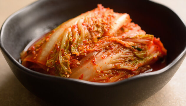Extreme close up of authentic Korean baechu kimchi fermented napa cabbage coated in vibrant red gochugaru chili paste and sesame seeds